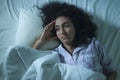 Dramatic night lifestyle potrait of young sad and depressed middle eastern woman with curly hair sleepless in bed awake feeling Royalty Free Stock Photo