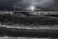 Dramatic ocean, dark cloudy sky with lightning lighthouse in fro