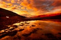 Dramatic orange sunset sky reflected in Scottish Loch