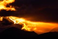 Dramatic orange and yellow sunset sky behind a range of majestic mountain peaks Royalty Free Stock Photo