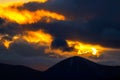 Dramatic orange and yellow sunset sky behind a range of majestic mountain peaks Royalty Free Stock Photo