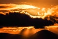 Dramatic orange and yellow sunset sky behind a range of majestic mountain peaks Royalty Free Stock Photo