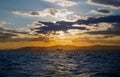 Dramatic panorama seascape shot of a lonely tanker silhouette in wavy blue ocean at a beautiful yellow orange sunset on a cloudy Royalty Free Stock Photo