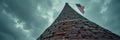 Dramatic perspective of brick tower with american flag against moody sky Royalty Free Stock Photo