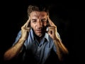 Dramatic portrait of attractive sad and depressed man with fingers on his head desperate suffering depression and headache having Royalty Free Stock Photo