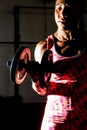 Dramatic portrait of fitness woman doing exercise for arm muscle