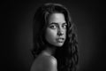 Dramatic portrait of a girl theme: Black and white portrait of a young beautiful girl on a dark background in the studio Royalty Free Stock Photo