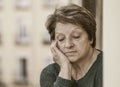 Dramatic portrait of mature woman on her 70s crying sad and depressed at home balcony feeling desperate suffering anxiety problem Royalty Free Stock Photo