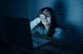 Scared woman on laptop in the dark feeling fear suffering online harassment and cyberbullying Royalty Free Stock Photo