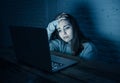 Scared woman on laptop in the dark feeling fear suffering online harassment and cyberbullying Royalty Free Stock Photo