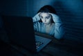 Scared woman on laptop in the dark feeling fear suffering online harassment and cyberbullying Royalty Free Stock Photo