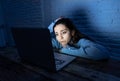 Scared woman on laptop in the dark feeling fear suffering online harassment and cyberbullying Royalty Free Stock Photo