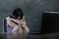 Dramatic portrait of scared and stressed teenager girl or young woman with laptop computer suffering cyber bullying stalked and in