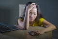 Dramatic portrait scared and stressed Asian Korean teen girl or young woman with laptop computer and mobile phone suffering cyber Royalty Free Stock Photo