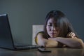 Dramatic portrait scared and stressed Asian Korean teen girl or young woman with laptop computer and mobile phone suffering cyber Royalty Free Stock Photo