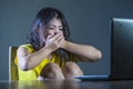 Dramatic portrait of scared and stressed Asian Korean teenager girl or young woman with laptop computer suffering cyber bullying s Royalty Free Stock Photo