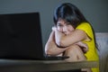 Dramatic portrait of scared and stressed Asian Korean teenager girl or young woman with laptop computer suffering cyber bullying s Royalty Free Stock Photo