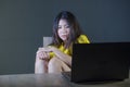 Dramatic portrait of scared and stressed Asian Korean teenager girl or young woman with laptop computer suffering cyber bullying s Royalty Free Stock Photo