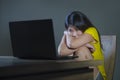 Dramatic portrait of scared and stressed Asian Korean teenager girl or young woman with laptop computer suffering cyber bullying s Royalty Free Stock Photo