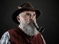 Dramatic portrait of senior smoking tobacco pipe Royalty Free Stock Photo