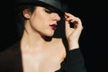 Dramatic portrait of sexy young girl in black hat with red lipstick Royalty Free Stock Photo