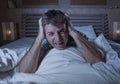Dramatic portrait of young attractive sad and depressed man lying in bed crying and screaming desperate suffering depression Royalty Free Stock Photo