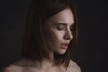 Dramatic portrait of a young beautiful brunette woman with short haircut in the studio.