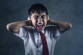Dramatic portrait of young desperate and abused schoolboy in uniform crying alone victim of bullying and abuse at school Royalty Free Stock Photo