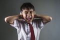 Dramatic portrait of young desperate and abused schoolboy in uniform crying alone victim of bullying and abuse at school Royalty Free Stock Photo