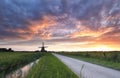 Dramatic purple sunset in Dutch countryside with windmill
