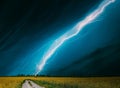 Dramatic Rain Sky With Rain Clouds On Horizon Above Rural Landscape Camola Colza Rapeseed Field. Country Road Royalty Free Stock Photo