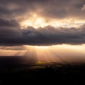 Dramatic rays of light shining on the English countryside below