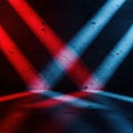 Dramatic red and blue spotlights illuminate a textured dark surface with striking shadows Royalty Free Stock Photo