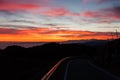 Dramatic red sky with reflections on guard rail road