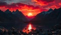 Dramatic red sun setting over a mountainous landscape with a lake or river in the foreground Royalty Free Stock Photo