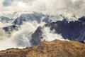 Dramatic rocky mountains in the clouds and sun shining, Dolomites