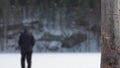 Dramatic scene of a dying man in a snowy field. A gaunt, exhausted man slowly walks along a snowy field