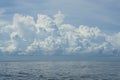 Dramatic scene of powerful raining white cloud, shades of blue sky background and deep blue sea with ocean water ripple Royalty Free Stock Photo