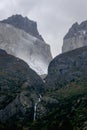 Dramatic scene of rocky mountains with small waterfall on a cloudy mist day Royalty Free Stock Photo