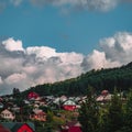 Dramatic scenic view of mountain village with clouds above the forest Royalty Free Stock Photo