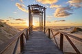 Dramatic sea sunset. The blinding sun hid behind the arch of the wooden bridge Royalty Free Stock Photo