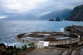 Dramatic seaside scene with a helicopter landing pad by the silent blue waters on a stormy day