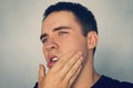 Dramatic Shot of a Man in Pain holding his Jaw. Toothache. A punch in the jaw Slap. Insult. The guy strokes his chin after shaving