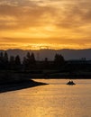 Dramatic shot of people on a paddle boat (pedalo) on the lake at sunset Royalty Free Stock Photo