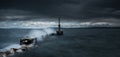 Dramatic shot of sea waves slamming against a jetty under a heavy cloudy sky