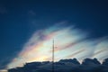 Dramatic silhouette scene of antenna with deep grey cloudy sky with cloud iridescence as a background