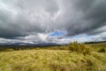 Dramatic sky of black clouds in the green field, wide angle view. Madrid