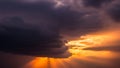 Dramatic Sky with Dark Clouds and Golden Sun Rays at Sunset stormy sunlight Royalty Free Stock Photo