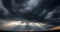 Dramatic sky with dark, heavy cloud cover pierced by sun rays Royalty Free Stock Photo