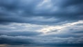 A dramatic sky filled with dense, dark gray storm clouds with patches of bright white light breaking through in the center Royalty Free Stock Photo